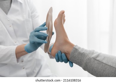 Doctor hands hold an orthopedic insole. Orthopedist tests the medical device. Orthopedic insoles on a white background. Foot care, comfort for the feet. Prevention of flat feet and foot diseases.