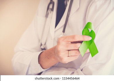 Doctor hands holding Lime Green ribbon, Mental health awareness, world mental health day, world kidney day, organ donation