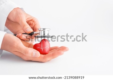 Doctor hands holding red heart and stethoscope. Cardiology, heart health and care, Health Day concept. Copy space.