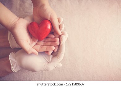 Doctor Hands With Medical Gloves Holding Child Hands And Red Heart, Health Insurance, Organ Donation, Charity During Covid, Saving Life, Thank You And Appreciation To Doctor, World Health Day