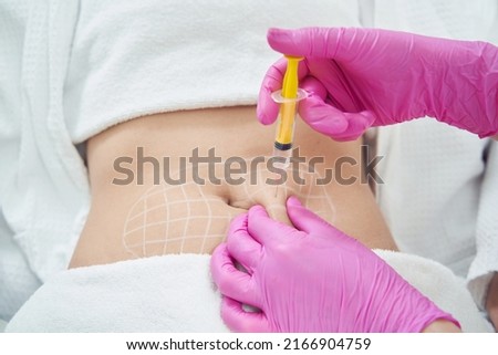 Doctor hands in pink gloves is doing anti cellulite reduction procedure