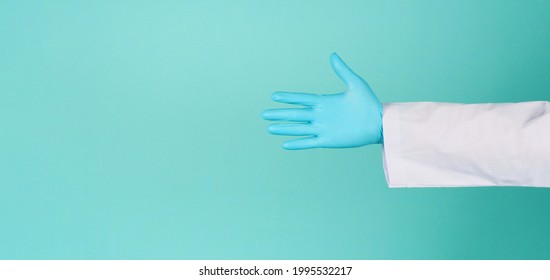 Doctor Hands Wear Blue Latex Glove On Green Mint OR Tiffany Blue Background.He Wear Long Sleeve Gown.Empty Hand