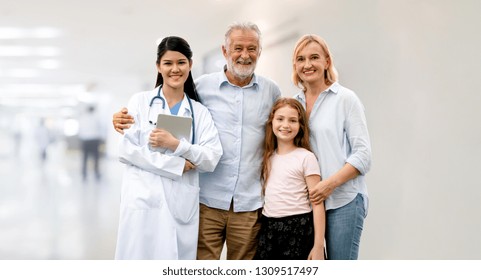 Doctor With Happy Family Of Mother, Father And Daughter At The Hospital. Medical Healthcare And Doctor Service.