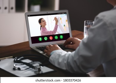 Doctor having online video consultation with business trainer at table, closeup