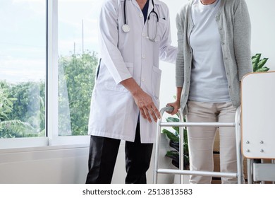 Doctor help old elderly caucasian woman uses walker and walking for physical therapy or unhealthy injury woman patient walking via four legs walker in the hospital room.  - Powered by Shutterstock