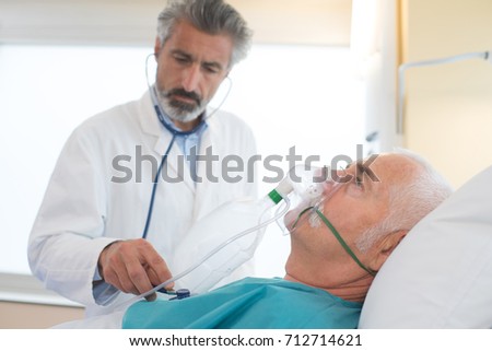 doctor helping an collapsed man wearing a breathing mask