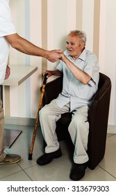 The Doctor Helping An Old Man Get Up From The Chair