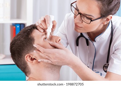 Doctor Helps The Patient And Gives The Eye Drops