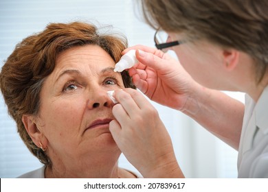 Doctor Helps The Patient And Gives The Eye Drops