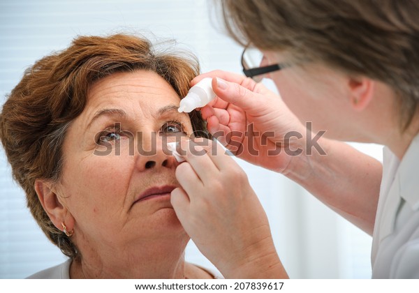 Doctor helps\
the patient and gives the eye\
drops