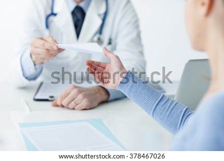 Doctor in his office giving a medical prescription to the patient, healthcare concept
