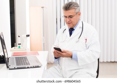 Doctor in his office with mobil phone - Powered by Shutterstock