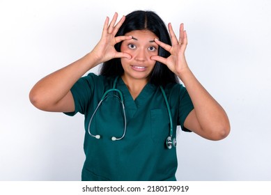 Doctor hispanic woman wearing surgeon uniform over white background keeping eyes opened to find a success opportunity.