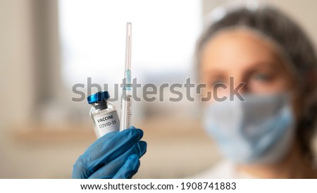 The doctor hold vaccine and syringe. Nurse is going to vaccinate people. Vaccine against the coronavirus covid-19 and pandemic. Vaccine vial for Covid-19 vaccination. Stop Covid. Back to normal life.