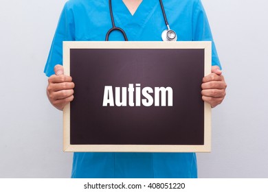 Doctor Holding Blackboard With Text Autism On White Background