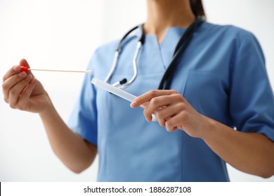 Doctor Holding Buccal Cotton Swab And Tube For DNA Test In Clinic, Closeup