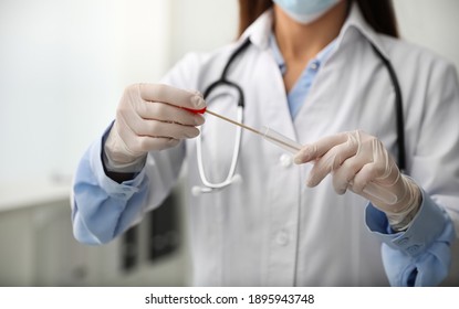 Doctor Holding Buccal Cotton Swab And Tube For DNA Test In Clinic, Closeup