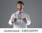 Doctor holding card with no smoking sign on gray background, selective focus