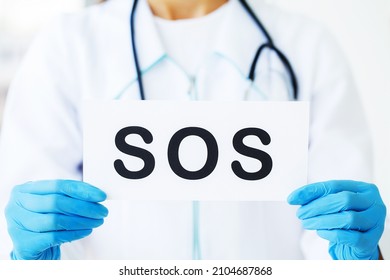 Doctor Holding a Card With Symbol Sos - Shutterstock ID 2104687868