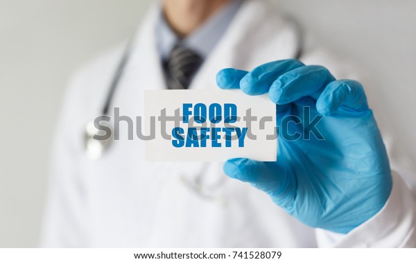 Doctor holding a card with text Food Safety,\
medical concept