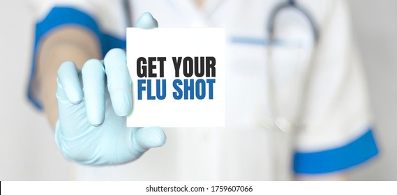 Doctor holding a card with text Get Your Flu Shot, medical concept