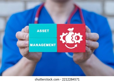 Doctor Holding Colorful Styrofoam Blocks With Icon And Inscription: ASSET MANAGEMENT. Healthcare, Business, Finance, Technology Concept. Medical Assets Management.