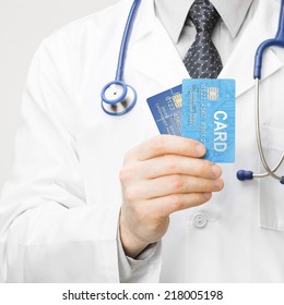 Doctor Holding Credit Cards In His Hand - Closeup Studio Shot - 1 To 1 Ratio