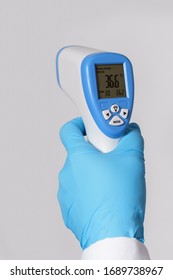 Doctor Is Holding A Digital Infrared Thermometer On Gray Background