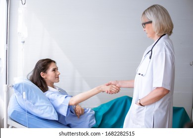 The Doctor Holding Hands To Cheer Up The Patient By The Bedside