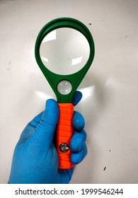 Doctor Holding A Magnifying Glass At Medical Laboratory.