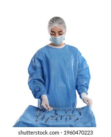 Doctor Holding Mayo Scissors Near Table With Different Surgical Instruments On Light Background