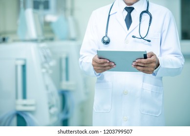 Doctor Holding Medical Records With A Dialysis Machine At Hospital Room