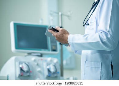 Doctor Holding Medical Records With A Dialysis Machine At Hospital Room