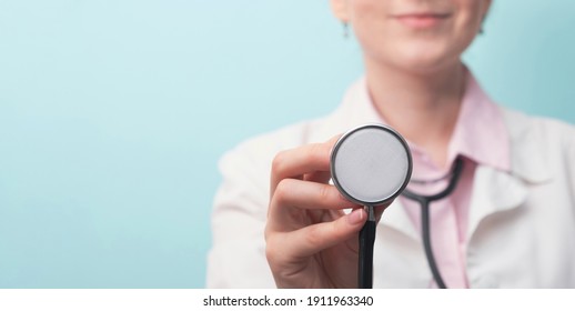 Doctor Holding Medical Stethoscope On Light Blue Background. Medicine And Healthcare Concept. Copy Space, Close Up, Banner