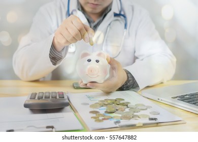 Doctor holding out your piggy bank wanting payment/ Your Savings To Pay Bill, insert coins to it,Stethoscope financial checkup or saving for medical insurance costs money plan fee  Lifestyle concept 