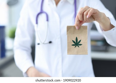 Doctor holding package with marijuana in clinic closeup. Treatment of depression with narcotic drugs concept