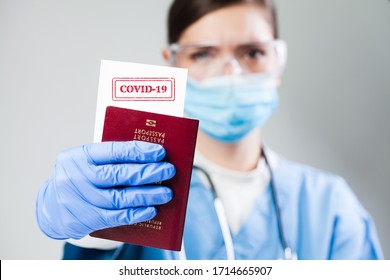 Doctor Holding A Passport With COVID-19 Sign Stamped Onto A White Paper,immunity Passport Or Risk-free Certificate Concept,recovered Coronavirus COVID19 Patients Being Issued Proof Of Convalescence 