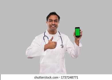 Doctor Holding Phone Showing Thumb Up Isolated. Indian Man Doctor Technology Medicine At Home. Phone Green Screen.