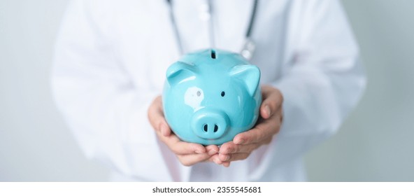 Doctor holding piggy bank and putting coin. and Healthcare cost, Money Saving, Health Insurance, Medical, Donation and Financial concepts - Powered by Shutterstock