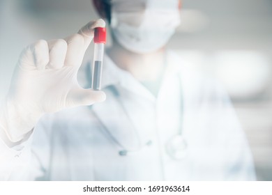 Doctor holding positive Covid-19 test. Coronavius outbreak crisis. Blood sample in a tube at lab.  - Shutterstock ID 1691963614