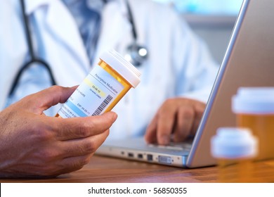 Doctor holding prescription bottle with laptop selective focus - Powered by Shutterstock