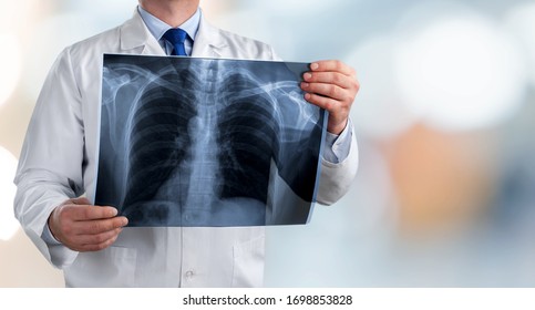 Doctor Holding Radiography X Ray Photo On Hospital Background