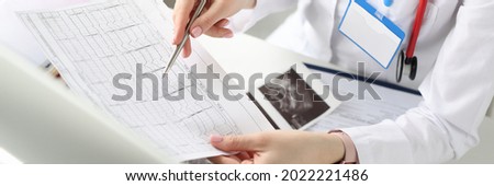 Doctor is holding result of decoded cardiogram in his hands