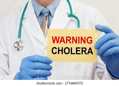 Doctor Holding Sign With Text Warning Cholera Closeup. Quarantine During Coronavirus Outbreak