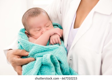 Doctor Holding Sleeping Newborn Baby In The Arms