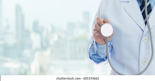 Doctor holding stethoscope with copy space medical background.
