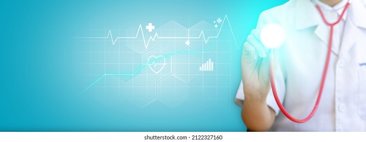 Doctor holding a stethoscope showing a heart wave graphic, line graph, bar graph, heart shape with wave cut in the middle. Modern medical technology concept. Banner background with copy space. - Shutterstock ID 2122327160