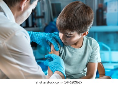 doctor holding syringe subcutaneous vaccine for child in the medical office / pediatrician vaccinating little boy in the pediatric clinic