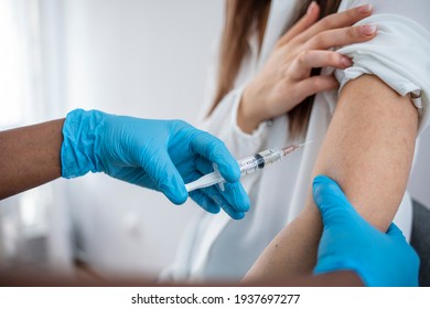 Doctor holding syringe and using cotton before make injection to patient in medical mask. Covid-19 or coronavirus vaccine. Woman with face mask getting vaccinated, coronavirus, covid-19 