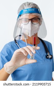 Doctor Is Holding Syringe With A Vaccine Before Make An Injection To Patient. Female Medical Specialist In Face Shield, White N95 Respirator And Gloves Doing Vaccination, Coronavirus, Covid-19.